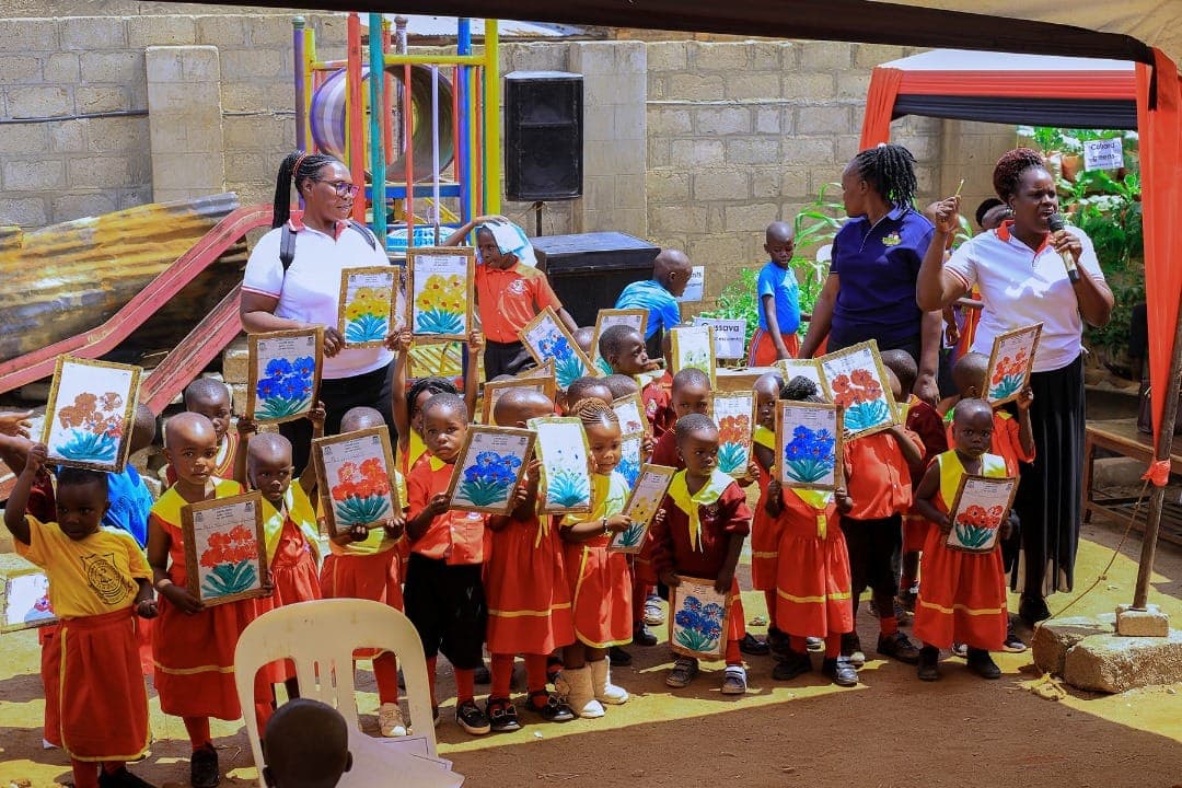 Nursery learners holding up their flower paintings